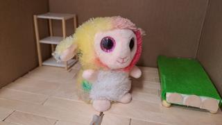 Leluhahmo sille rakennetussa huoneessa. Huoneessa on sänky ja pieni hyllykkö.